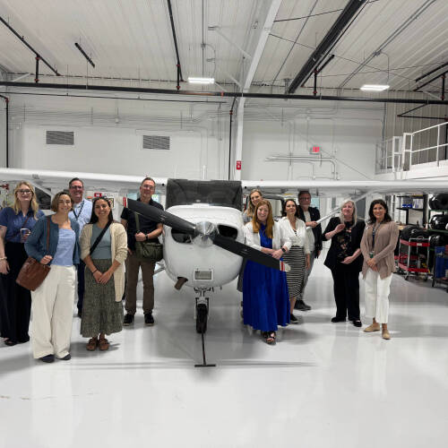 people in front of airplane in a hangar
